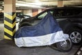 Single motorcycle is in warm underground parking garage covered with tent Royalty Free Stock Photo
