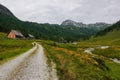 single mountain biker driving through alpine huts on a curvy dirt road Royalty Free Stock Photo