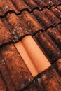 Single new clay roof tile on old rustic terracotta roofing as background
