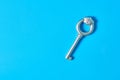 Single old antique silver key lies on blue color desk. Copy space Royalty Free Stock Photo