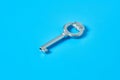 Single old antique silver key lies on blue color desk Royalty Free Stock Photo