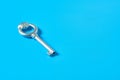 Single old antique silver key lies on blue color desk Royalty Free Stock Photo