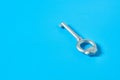 Single old antique silver key lies on blue color desk Royalty Free Stock Photo
