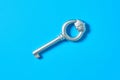 Single old antique silver key lies on blue color desk. Top view Royalty Free Stock Photo