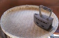 Single old grunge rust iron hot equipment on circle wooden basket. heat vintage ironing coal domestic housework