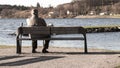 Single old man on sits on a bench
