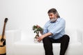 Single old men on white couch with a bonsai