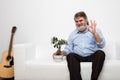 Single old men on white couch with a bonsai