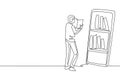 Single one line drawing male student reading book while standing in front of large smartphone with bookshelf on screen. Mobile Royalty Free Stock Photo