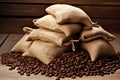 Single open burlap satchel on side with whole coffee beans spilling out over wood panel Royalty Free Stock Photo