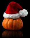 Single orange pumpkin with Christmas Santa hat Royalty Free Stock Photo