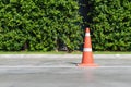 Single orange traffic cone on concrete street road