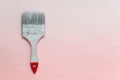 Single paint brush with red tip on pink backgound