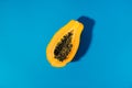 single papaya fruit cutter on half on blue background