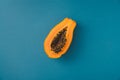single papaya fruit cutter on half on blue background