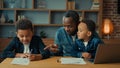 Single parent African American father man babysitter private teacher with two boys kids children help little schoolboy Royalty Free Stock Photo