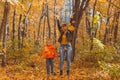 Single parent family playing with autumn leaves in park. Happy mom and son throw autumn leaves up in fall park. Royalty Free Stock Photo