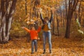 Single parent family playing with autumn leaves in park. Happy mom and son throw autumn leaves up in fall park. Royalty Free Stock Photo