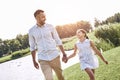 Single parent, Father and daughter walking on a grassy field hol