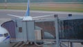 Single passenger boarding on airplane through an glass airbridge.