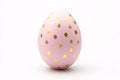Single pastel pink Easter egg with golden dots on white background Royalty Free Stock Photo