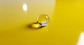 Single clear glass marble on a bright yellow glossy surface Royalty Free Stock Photo