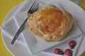 Single person breakfast of sweet pastry with fruit jam and a cup of hot tea on a colorful background