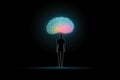 A single person stands proud illuminated by the light of an illuminating brain symbolizing the power of Psychology