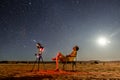 Single person stargazing with telescope under clear sky and full moon