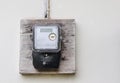 Single phase electricity meter on white concrete wall outside a house Royalty Free Stock Photo