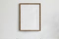 Single picture mockup poster hanging in the middle of white wall. Portrait large 50x70, 20x28, a3,a4. Empty wooden frame Royalty Free Stock Photo