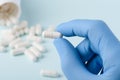 Pill in scientist hand with bottle on background Royalty Free Stock Photo