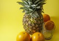 Single pineapple isolated on yellow background with empty glass Royalty Free Stock Photo