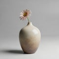 A single pink Gerbera daisy adorns a smooth, gradient ceramic vase. The vase features earthy tones, Royalty Free Stock Photo