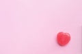 Single Pink Valentine`s day heart shape candy on empty pastel pi