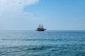 Single pirate schooner among blue water off the coast of Alanya Turkey. One tourist ship on the horizon. Background with copy