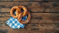 A single pretzel resting on a blue and white checkered napkin, ready for snacking Royalty Free Stock Photo