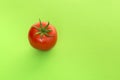 Single real tomato seen at its top on a green background