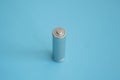 A single rechargeable battery on blue background. Silver alkaline AA battery for different device. Energy. Royalty Free Stock Photo