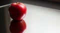 A single red apple rests on a reflective surface Royalty Free Stock Photo