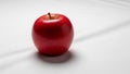 A single, red apple with a smooth, glossy surface is placed on a white fabric background. The apple Royalty Free Stock Photo