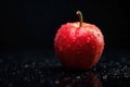 A single red apple with water droplets on a dark reflective surface. Generative AI Royalty Free Stock Photo