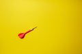 Single red arrow dart isolated on yellow background