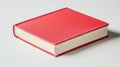 A single red book on a white surface Royalty Free Stock Photo