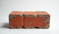 Single red brick isolated on white background. Old worn construction material shows rough texture with visible mortar residue. Royalty Free Stock Photo