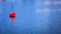 Single red buoy on calm blue sea surface Royalty Free Stock Photo