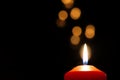 Single red candle burning in darkness with bokeh Royalty Free Stock Photo