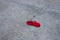 Single red child slipper on asphalt road. Lost kid shoe on street. Safe driving with kids concept. South Asia traffic Royalty Free Stock Photo