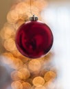 Single Red Christmas Ornament hanging in front of lights Royalty Free Stock Photo