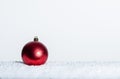 Single red Christmas ornament on snow Royalty Free Stock Photo